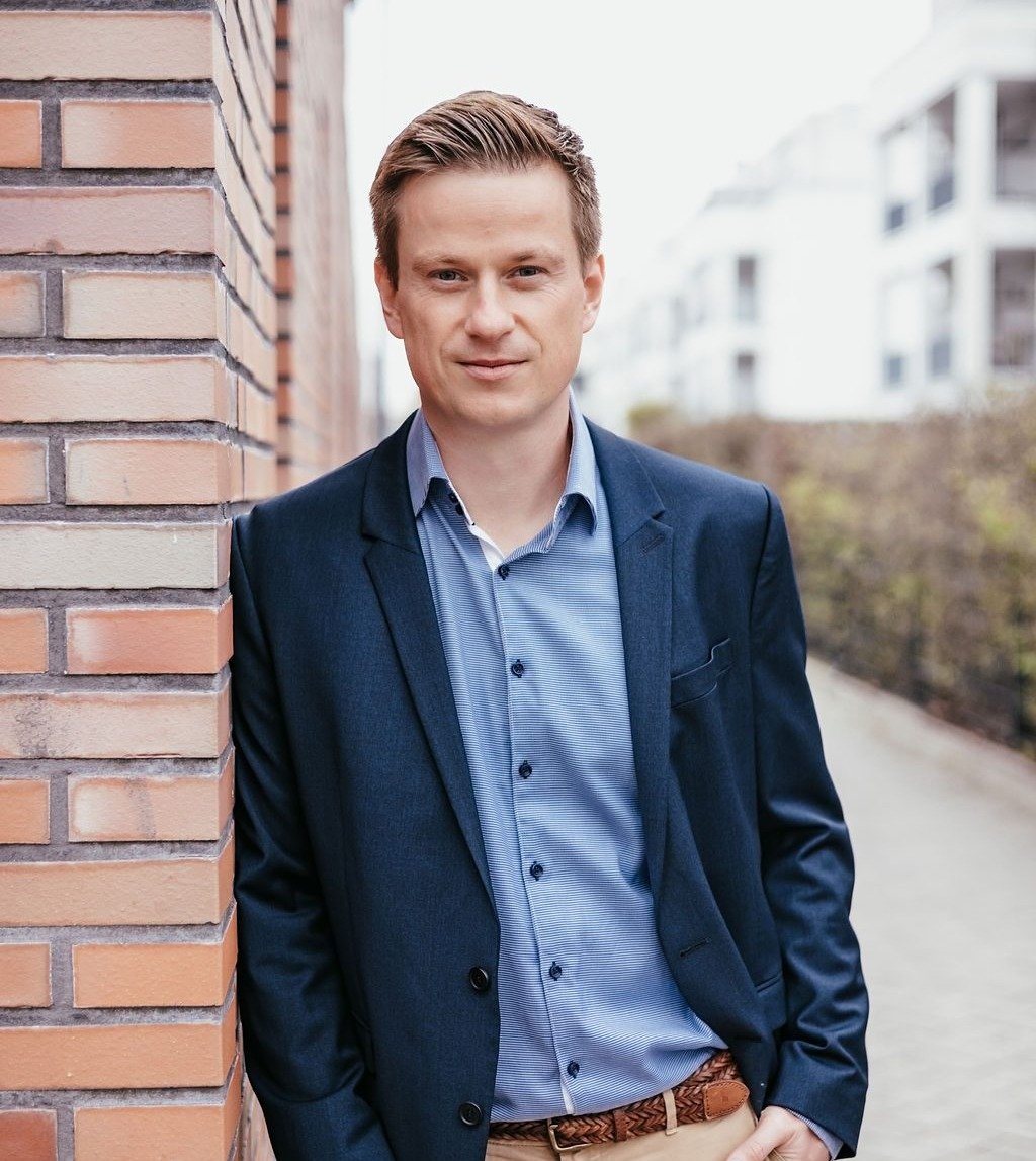Alexander Weinzetl, Unternehmer-Coach, an einer Ziegelwand